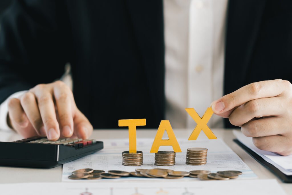 Image of businessman's hand calculating numbers and a word tax to describe zero tax in UAE