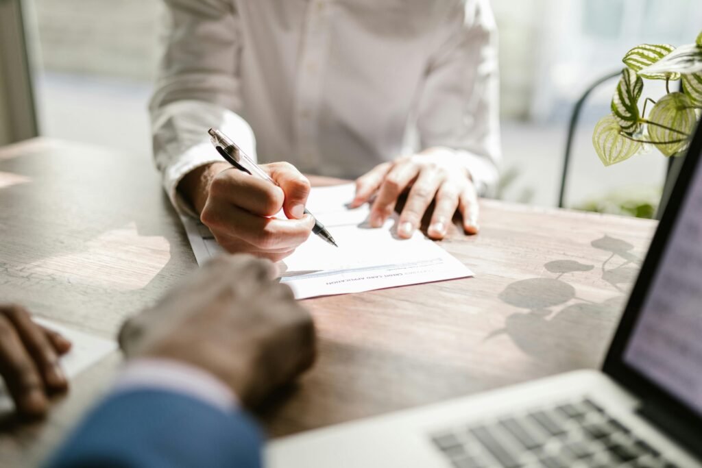 Close-up of a Person Signing a Visa Document