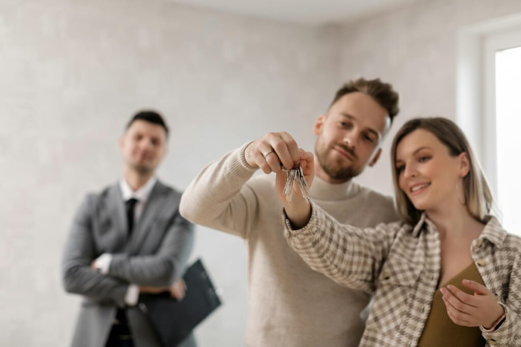 Image of a couple holding their keys with real estate agent