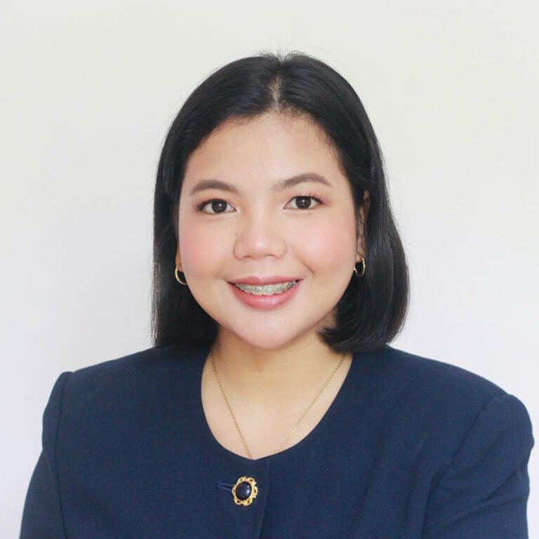 Headshot of a smiling woman in a navy jacket against a white background