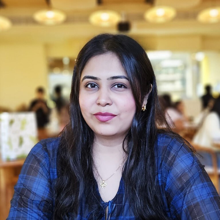 Portrait of a woman with long dark hair in a blue checked top